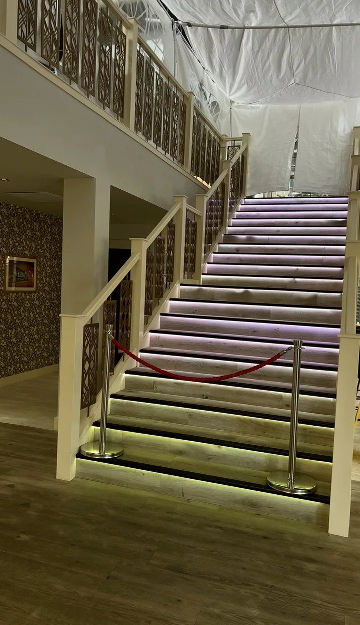 The lit staircase with a red rope, leading up to the event space that is being built