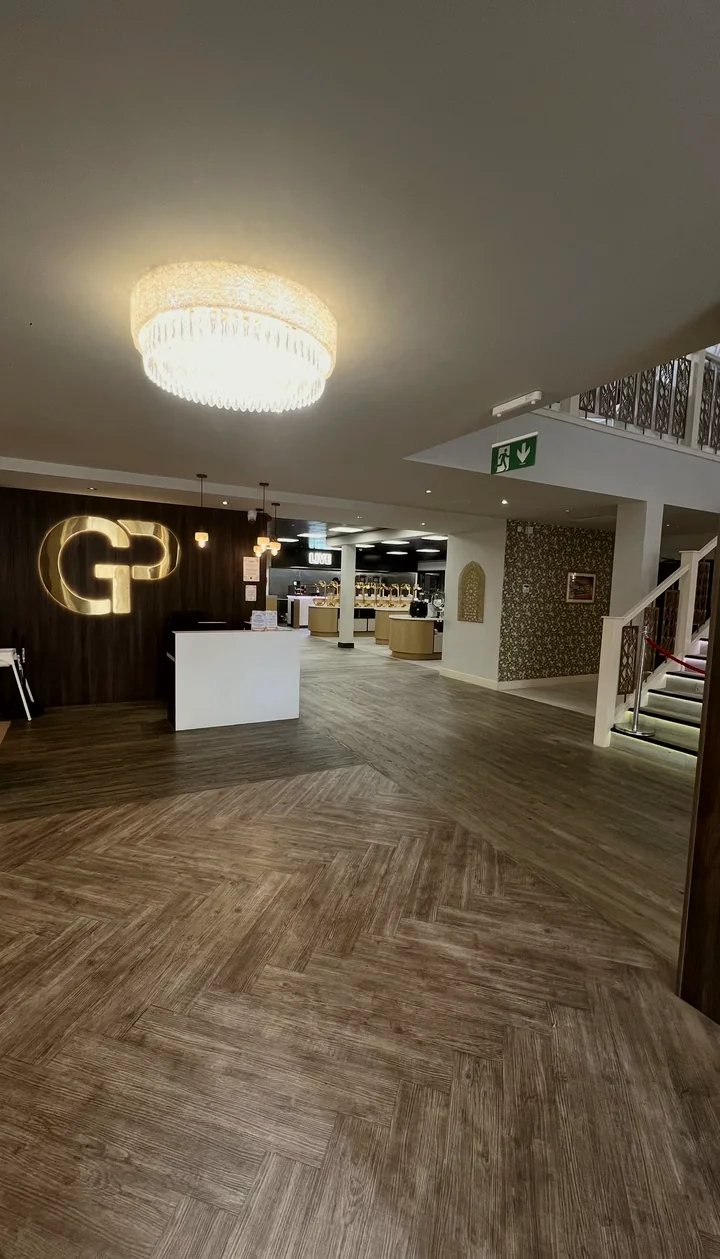 The Golden Palms lobby: crystal chandelier, gold GP sign at reception and the buffet beyond