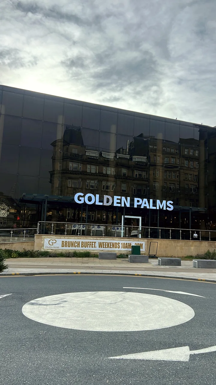 The glass frontage of Golden Palms with its sign, on Hall Ings