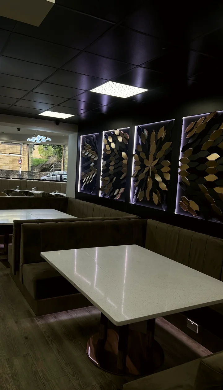 Velvet booths beneath gold and black petal wall art