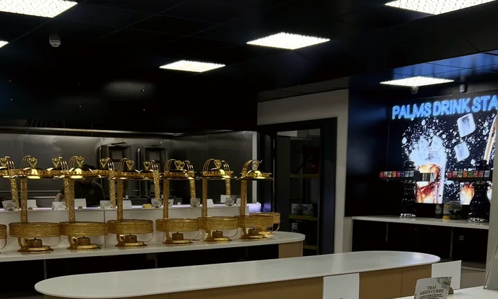 A row of ornate gold serving domes on the buffet counter