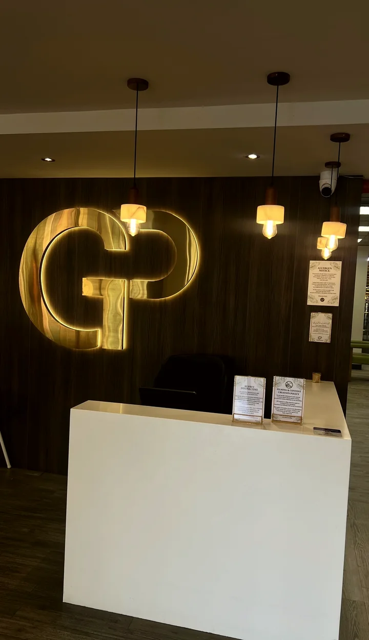 The reception desk in front of the glowing gold GP sign